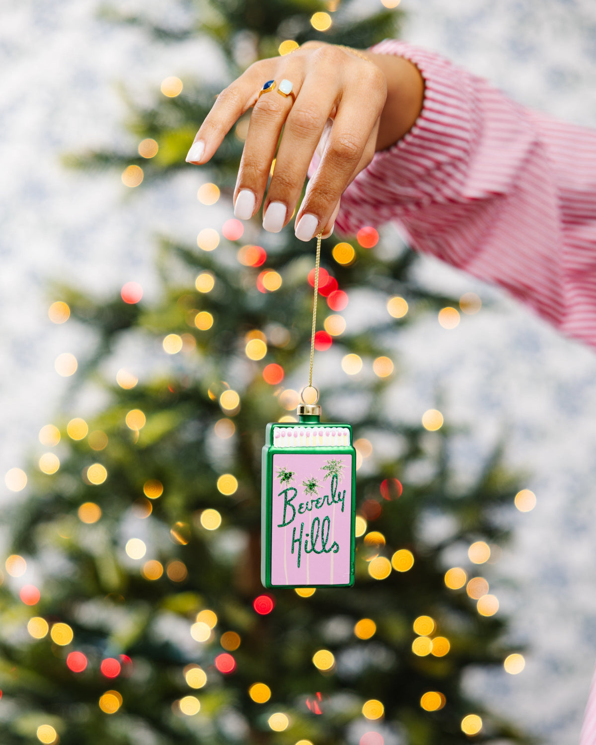 Matchbook ornament held up, green trim and 'Beverly Hills' text with gold hanging loop