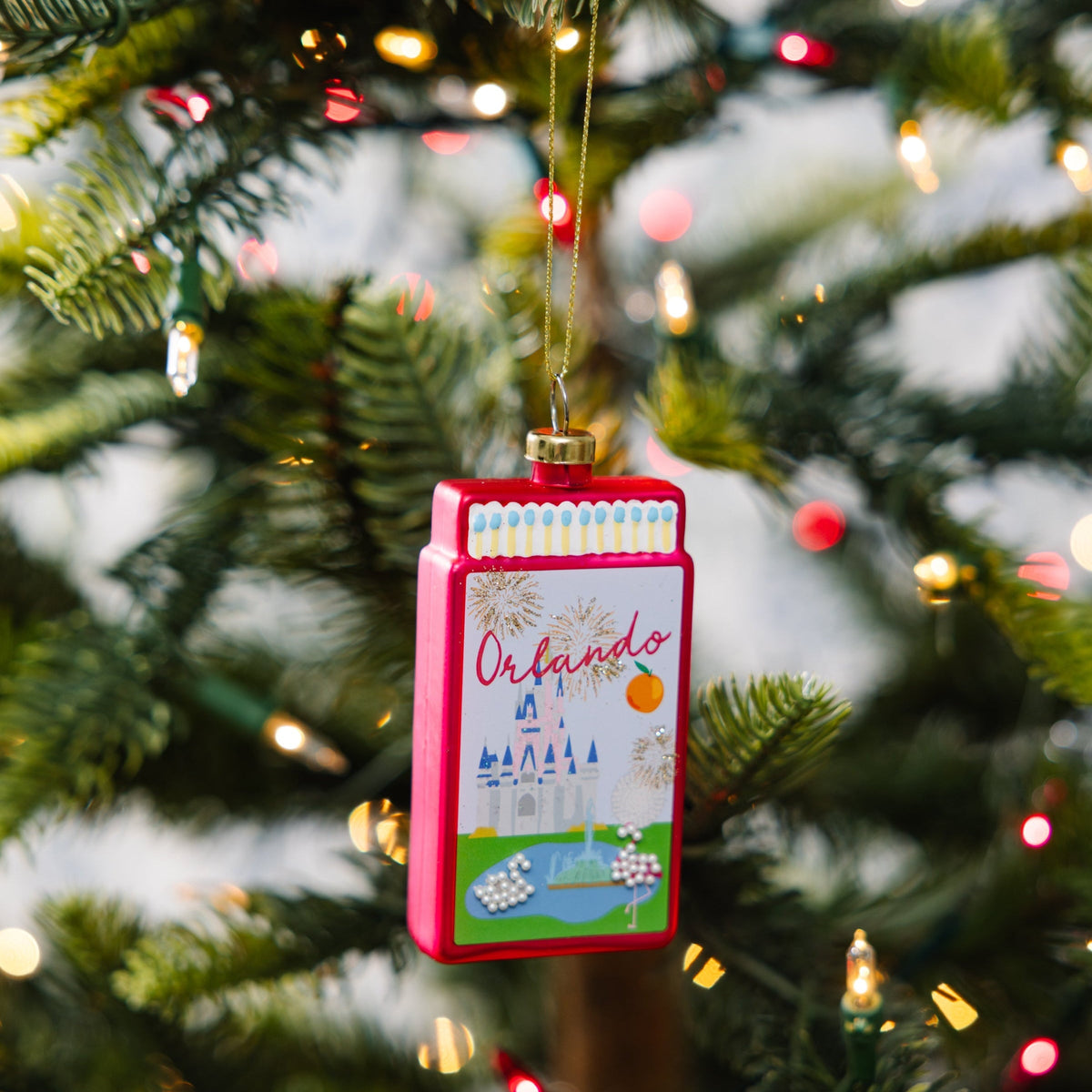 Orlando matchbook ornament hanging on Christmas tree, red border and gold loop
