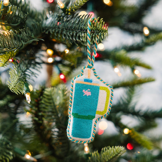 Needlepoint tumbler mug ornament hanging from a loop, teal with pink icon and yellow trim