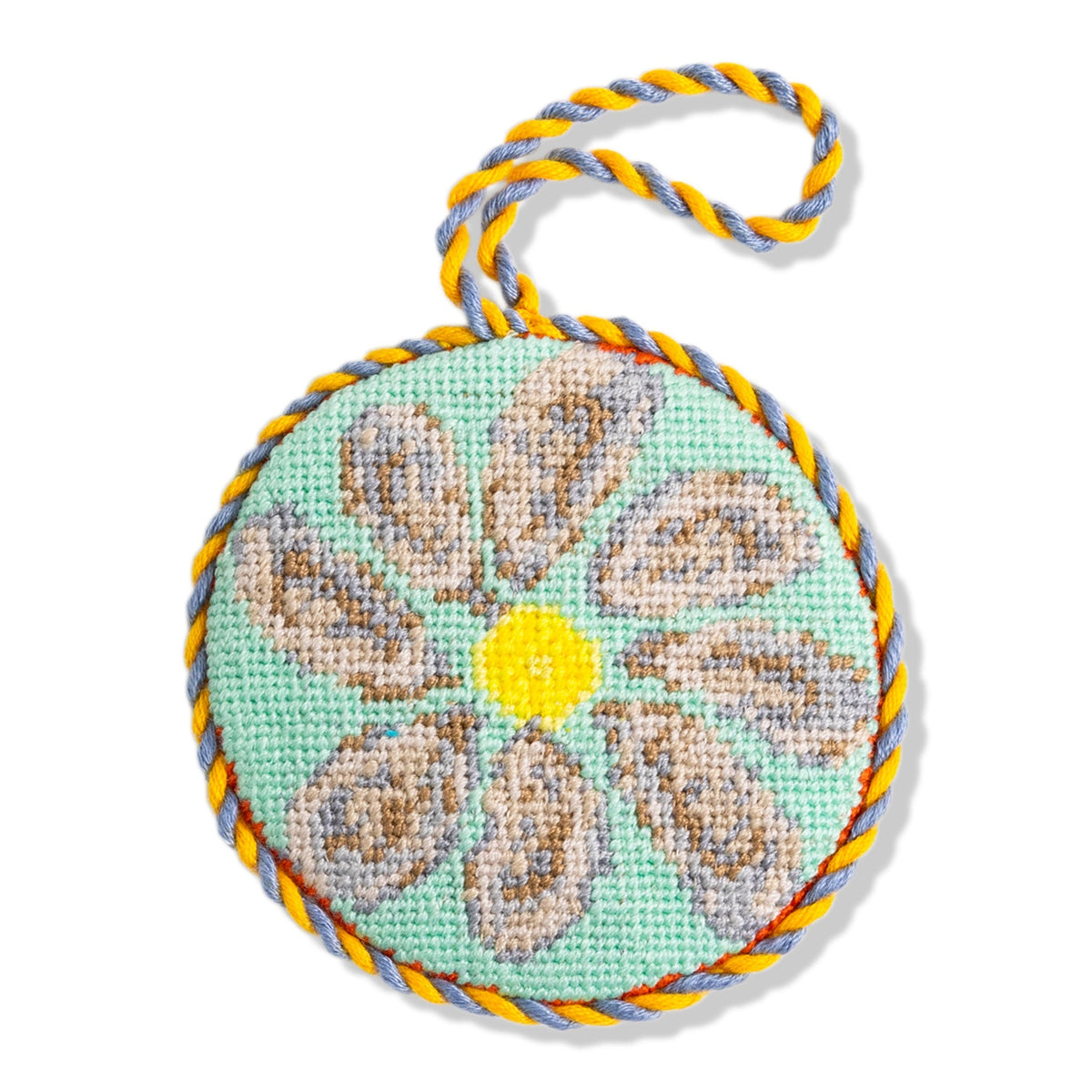Oyster needlepoint icon ornament, teal circle with yellow center and braided hanging loop
