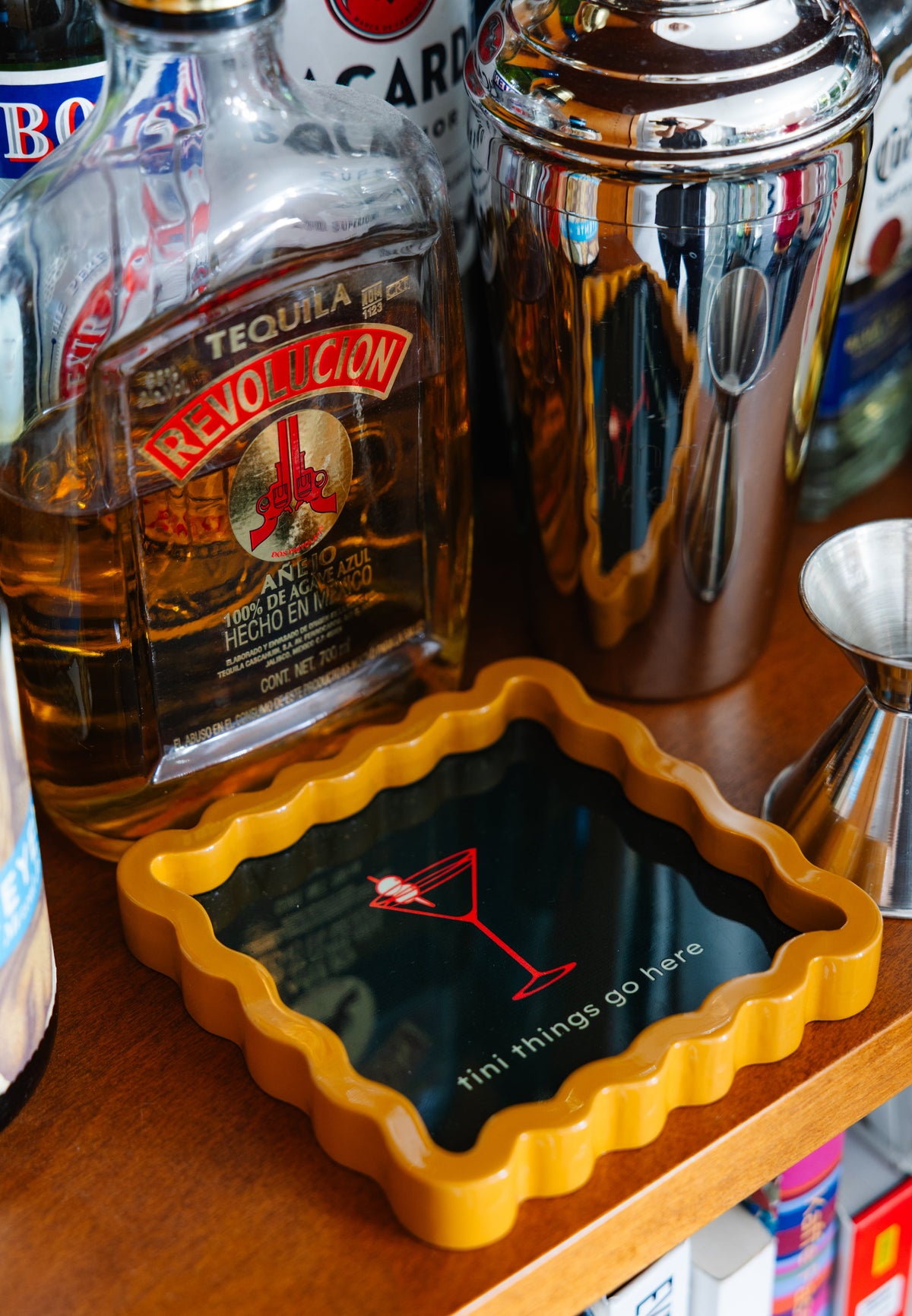 Scalloped lacquer tray with orange edge and dark green insert, martini icon and “tini things go here”
