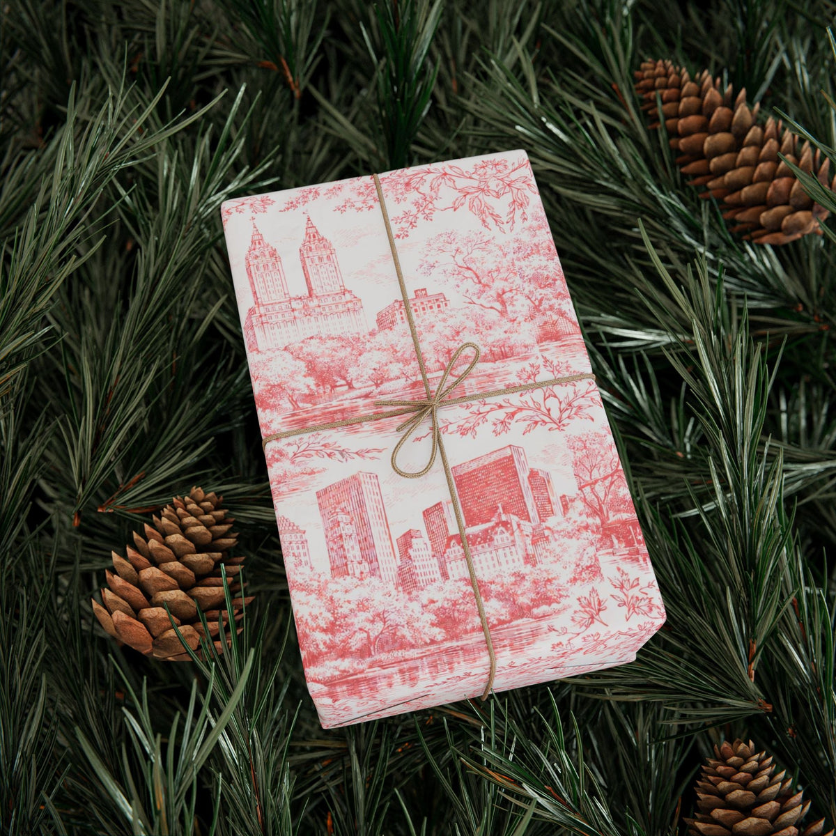 Red and white toile wrapping paper gift wrapped box on evergreen branches