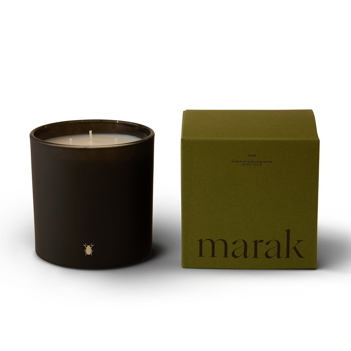Dark marak pine candle beside green box packaging