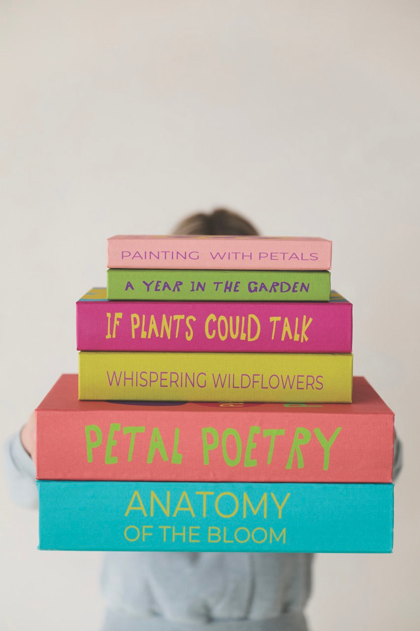 Floral canvas storage book box with stacked colorful book spines on a shelf