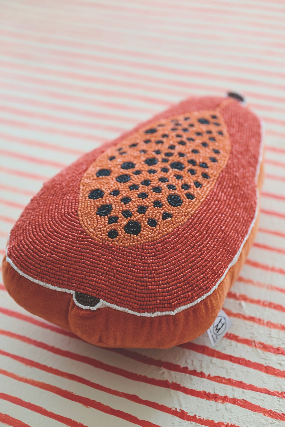 Papaya-shaped accent pillow front, orange beaded surface with black dot pattern