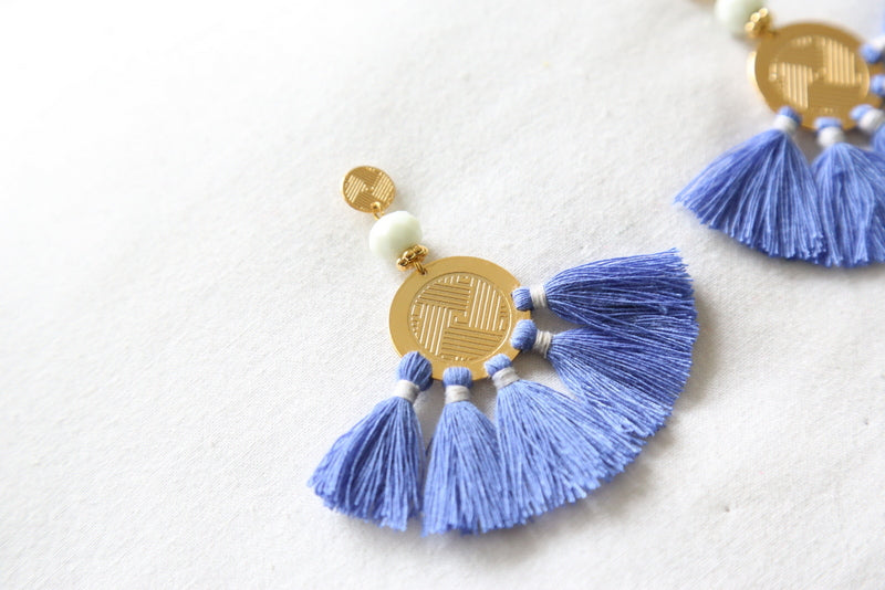 Blue tassel drop earring with gold medallion, white beads, and braided blue fringe