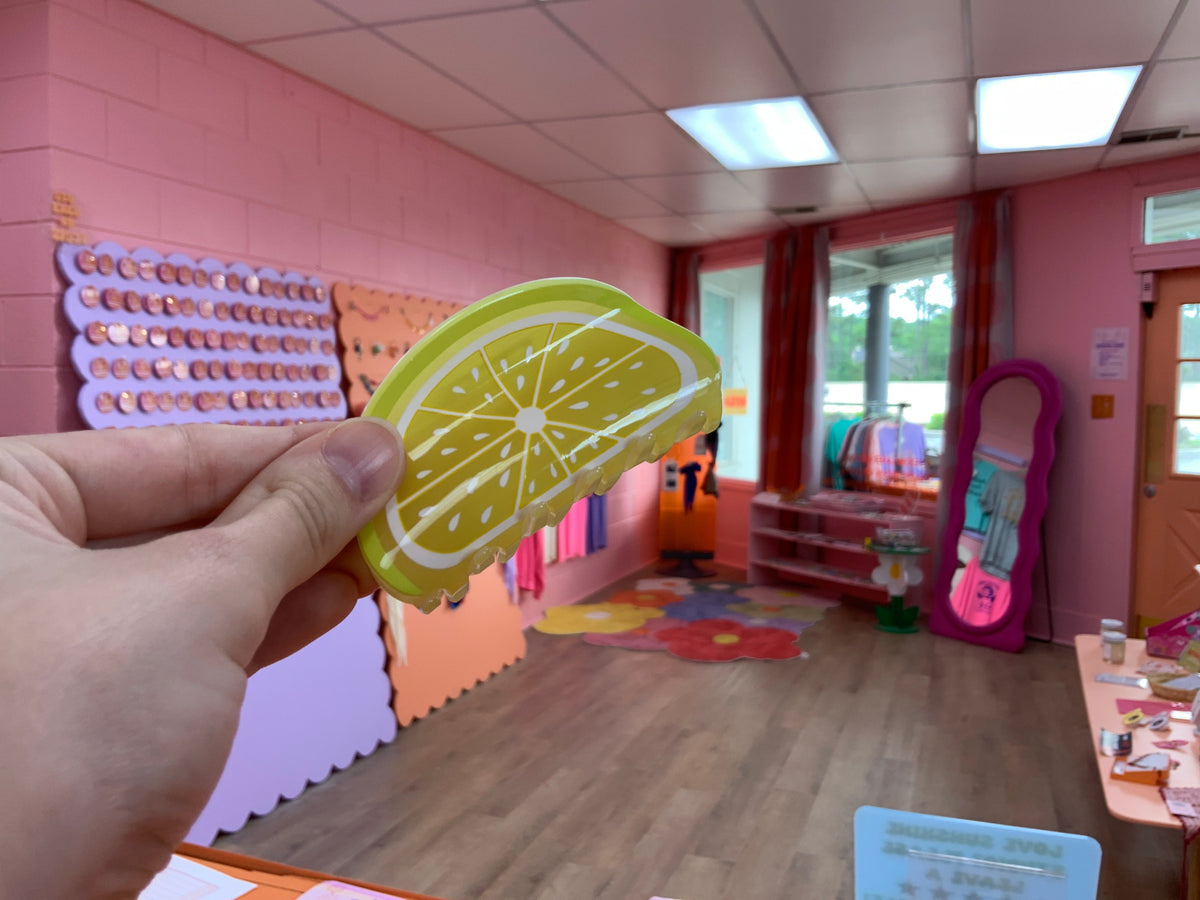 Lime slice fruit hair claw with green rind and pale yellow interior, curved grip