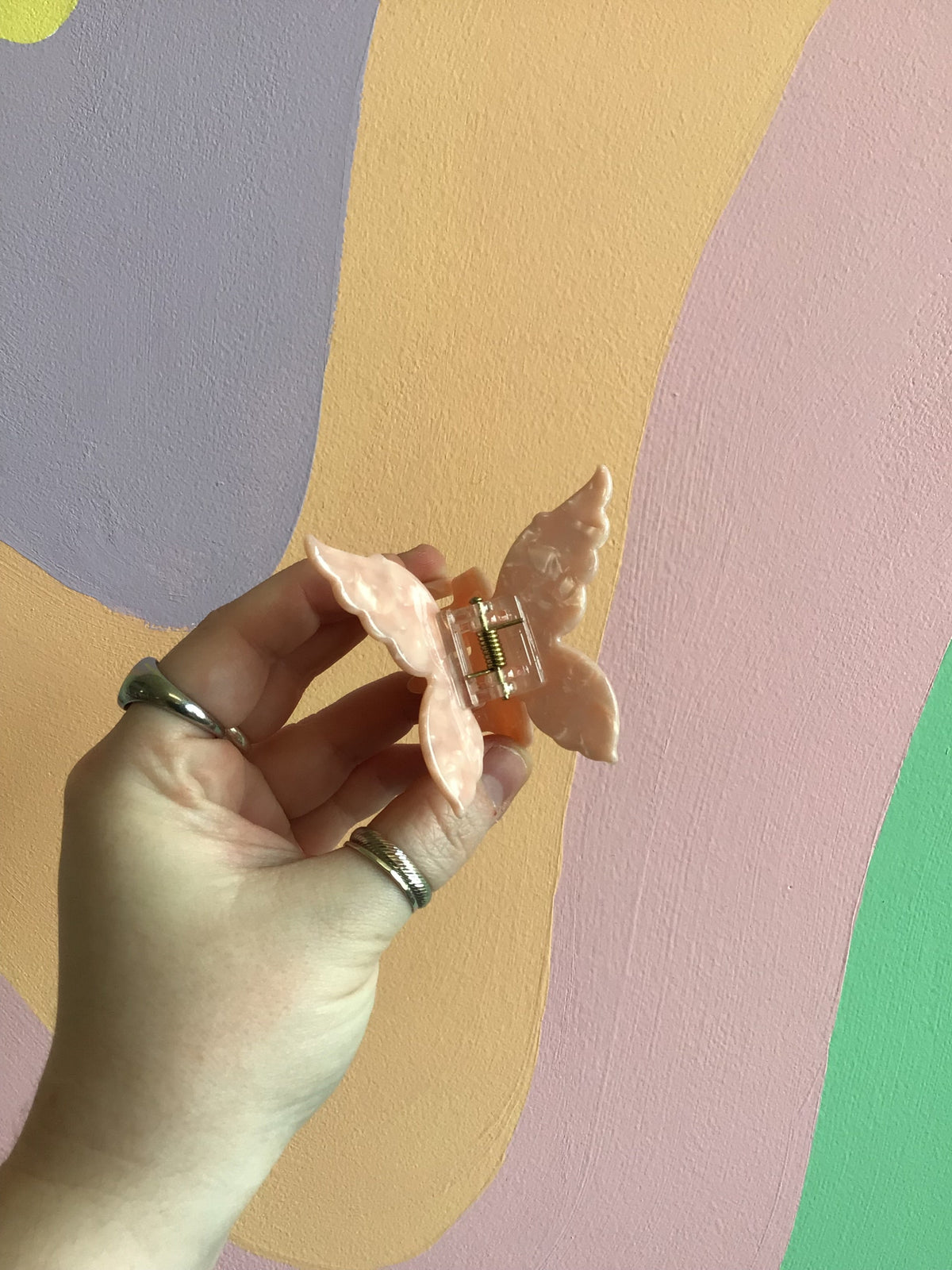 Butterfly hair claw with peach-pink iridescent wings and metal hinged clip