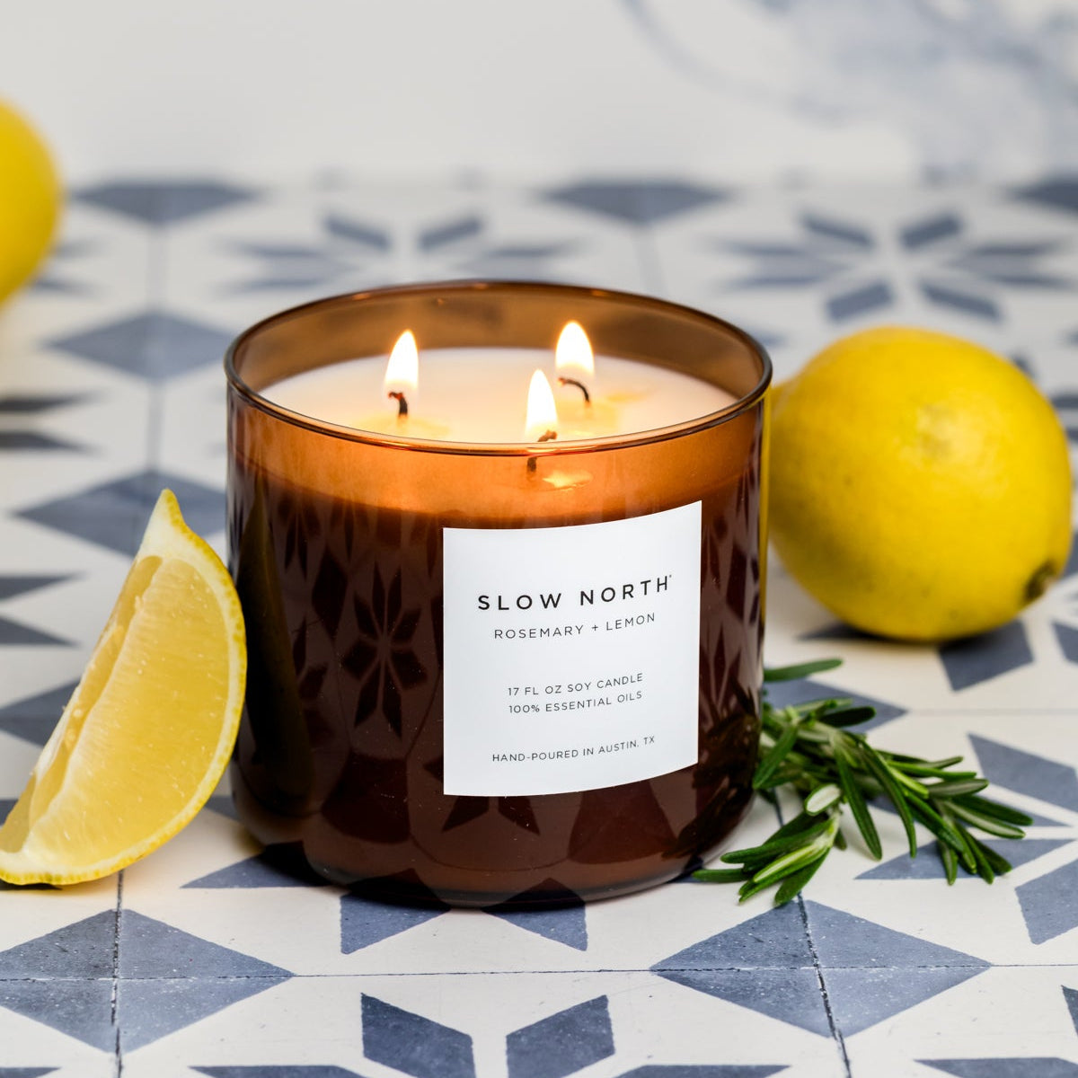 Brown 3-wick soy candle with three lit flames and front label