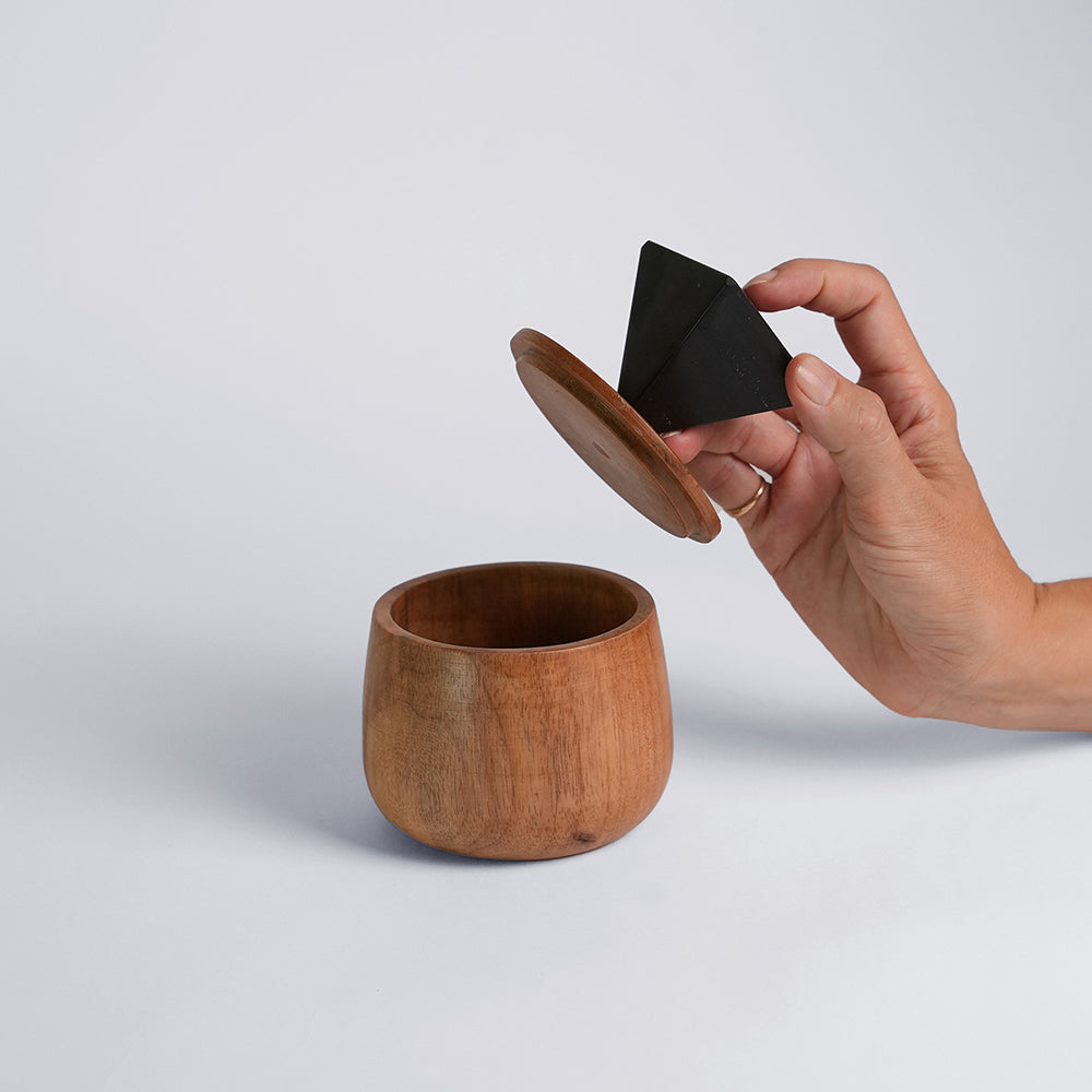 Round wooden jewel box with black triangular lid, open