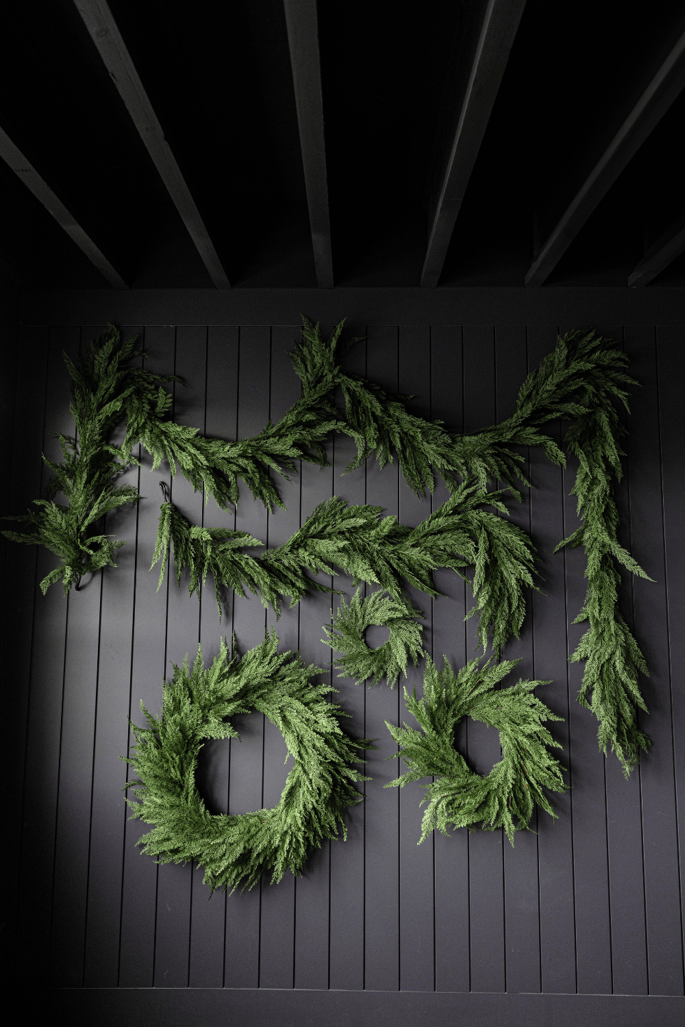 Green cypress leaf wreath with layered branches and multiple circular openings