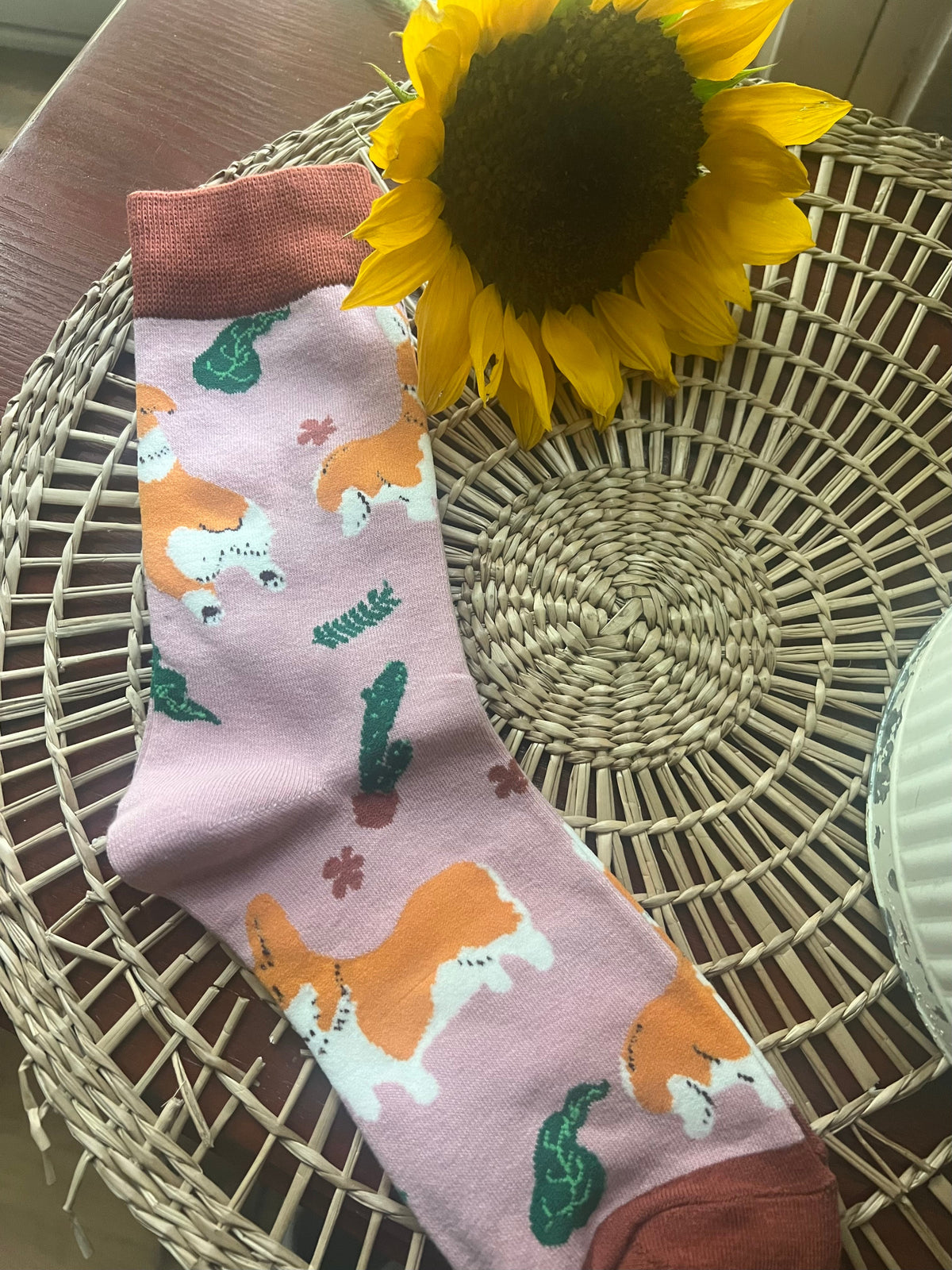 Corgi socks with pink cuff, orange dog and green leaf pattern on light lavender fabric