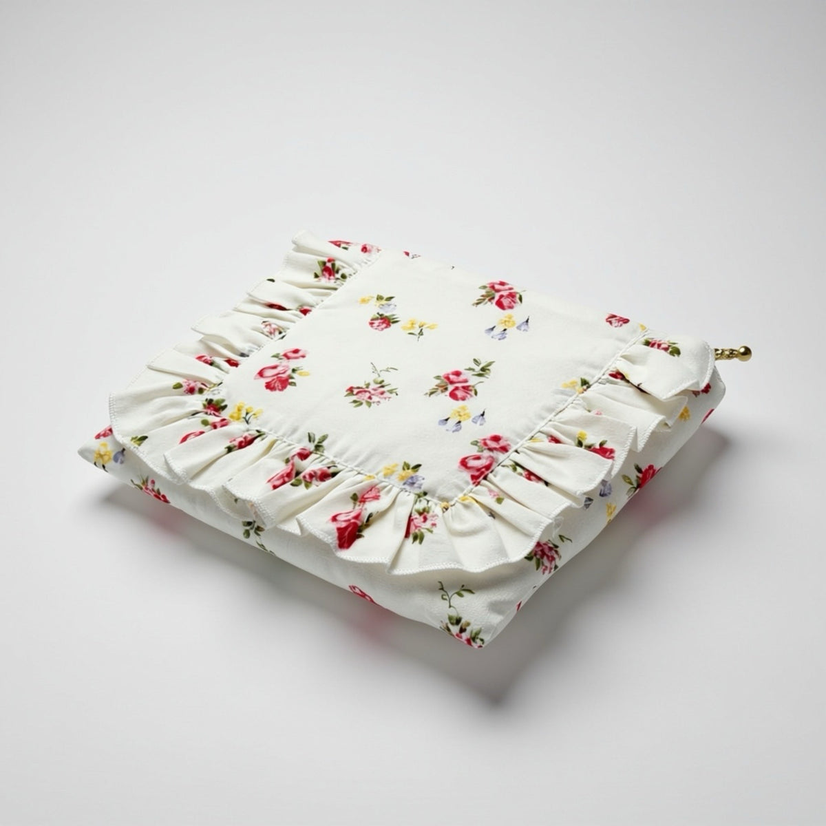 White floral ruffle zipper pouch, angled view with brass zipper pull
