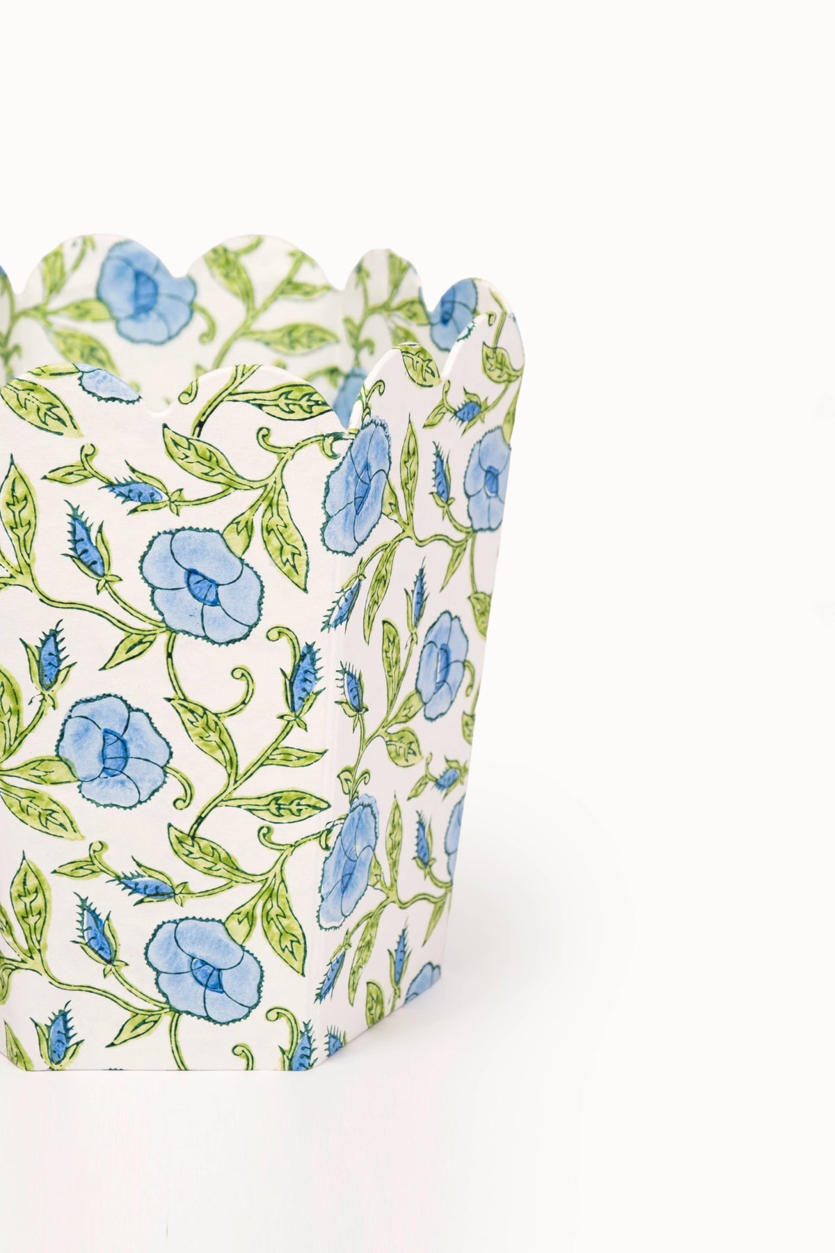 Side view of collapsible fabric basket with blue floral and green vine block print.