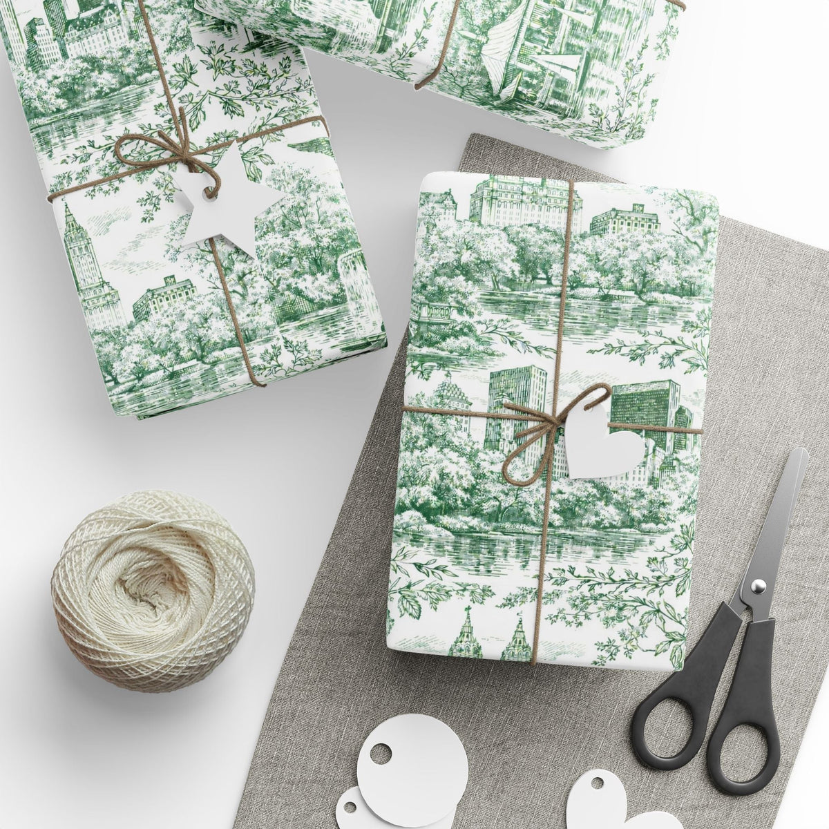 Green toile wrapping paper roll with New York skyline and trees, tied with twine