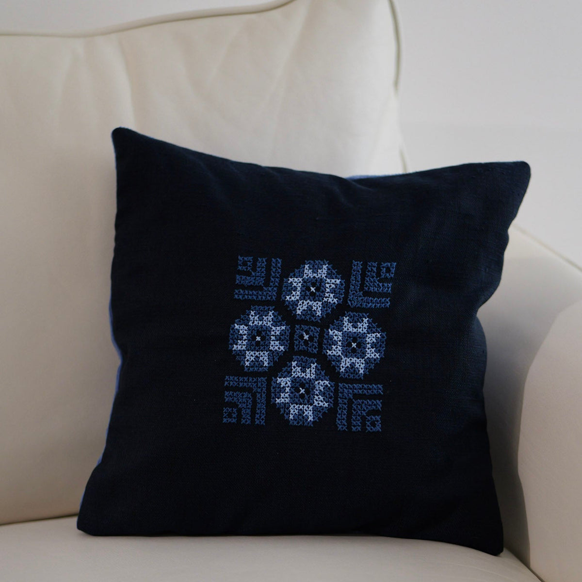 Dark blue pillow cover with blue-and-white cross-stitch geometric motif embroidery