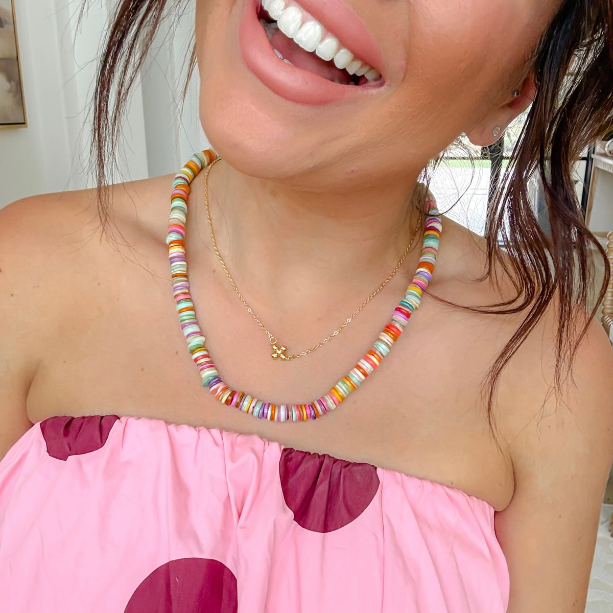 Multicolor bead gemstone necklace worn with small gold-tone charm pendant