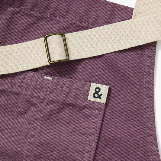 Lavender purple apron with adjustable cream waistband strap and sewn brand patch