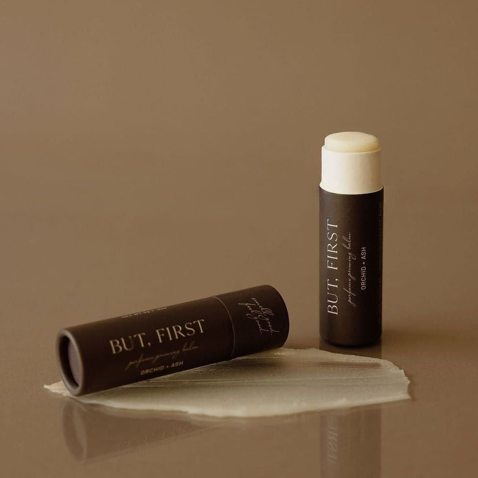 BUT, FIRST perfume priming balm tube with white cap and shown balm smear