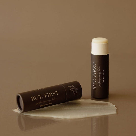 BUT, FIRST perfume priming balm tube with white cap and shown balm smear