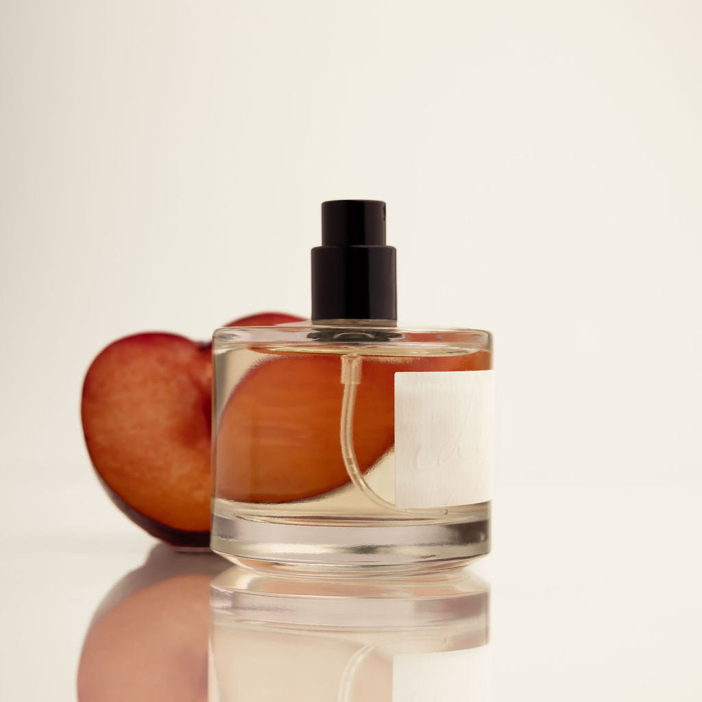 IDYLL perfume bottle with black cap, clear glass with amber tint