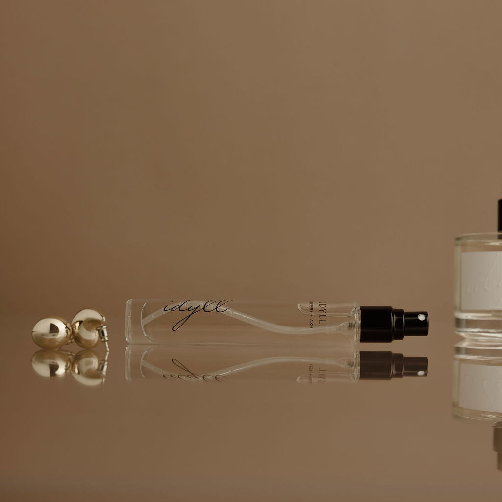 Pair of clear travel perfume sprayer bottles with black nozzles