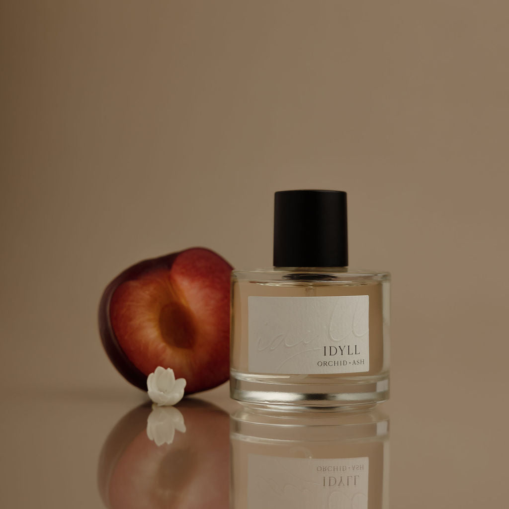 IDYLL perfume bottle with clear glass body and black cap, front label visible