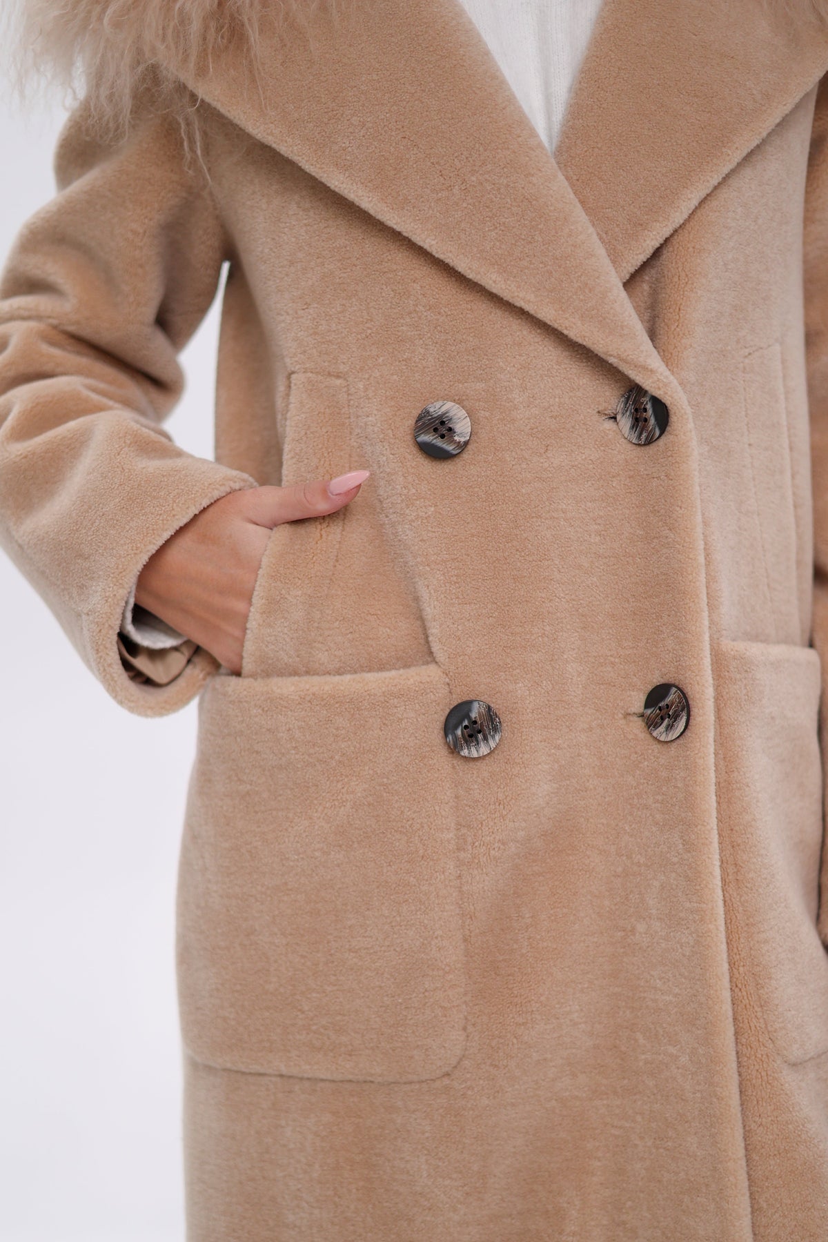 Close-up of the coat's double-breasted buttons and front patch pocket