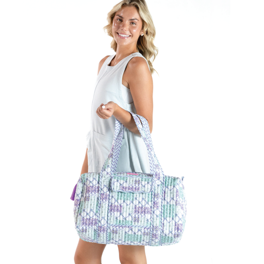 Quilted patch duffle bag with purple and green pattern, shoulder carry handles