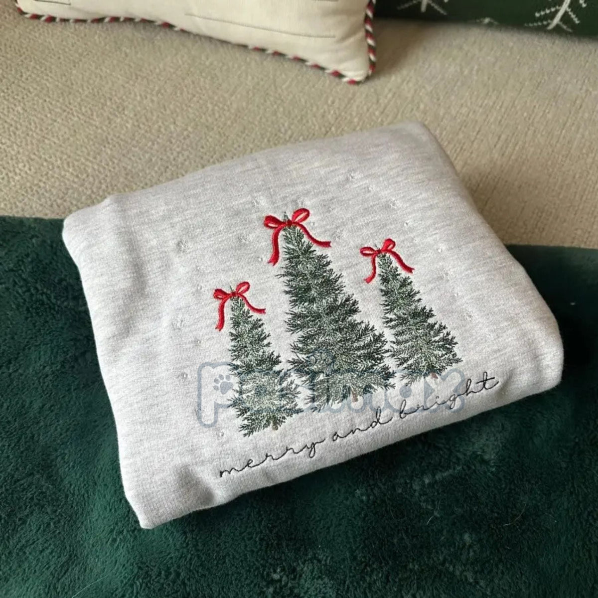 Folded sport grey sweatshirt with embroidered Christmas trees and red bow accents
