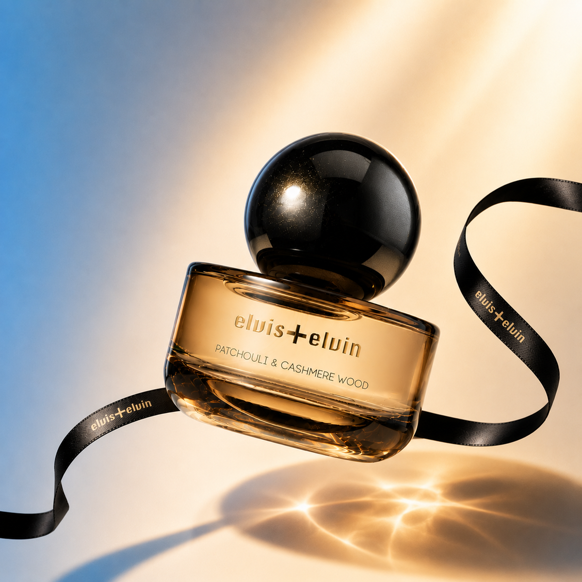 Patchouli and Cashmere Wood perfume bottle with black cap and attached ribbon