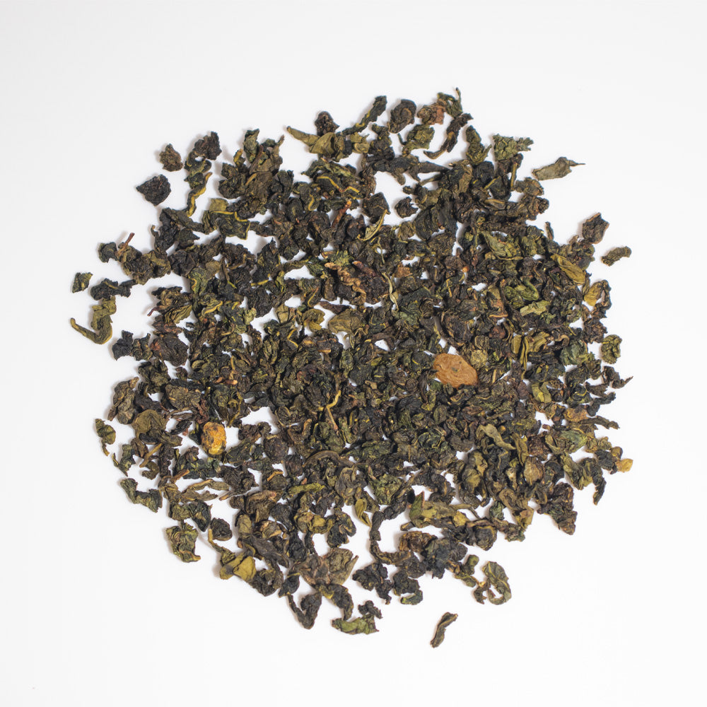 Loose leaf flavored oolong tea pile, dark green with small broken leaf pieces