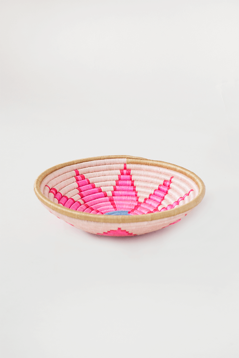 Shallow round woven tray with natural rim and pink flower weave, side view