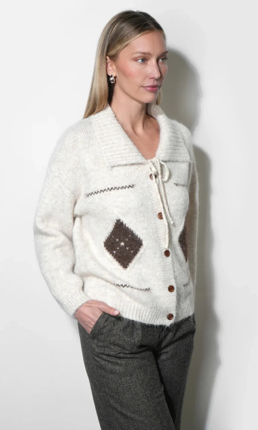 Cream knit cardigan with button front, tie neckline detail, and brown diamond patches.