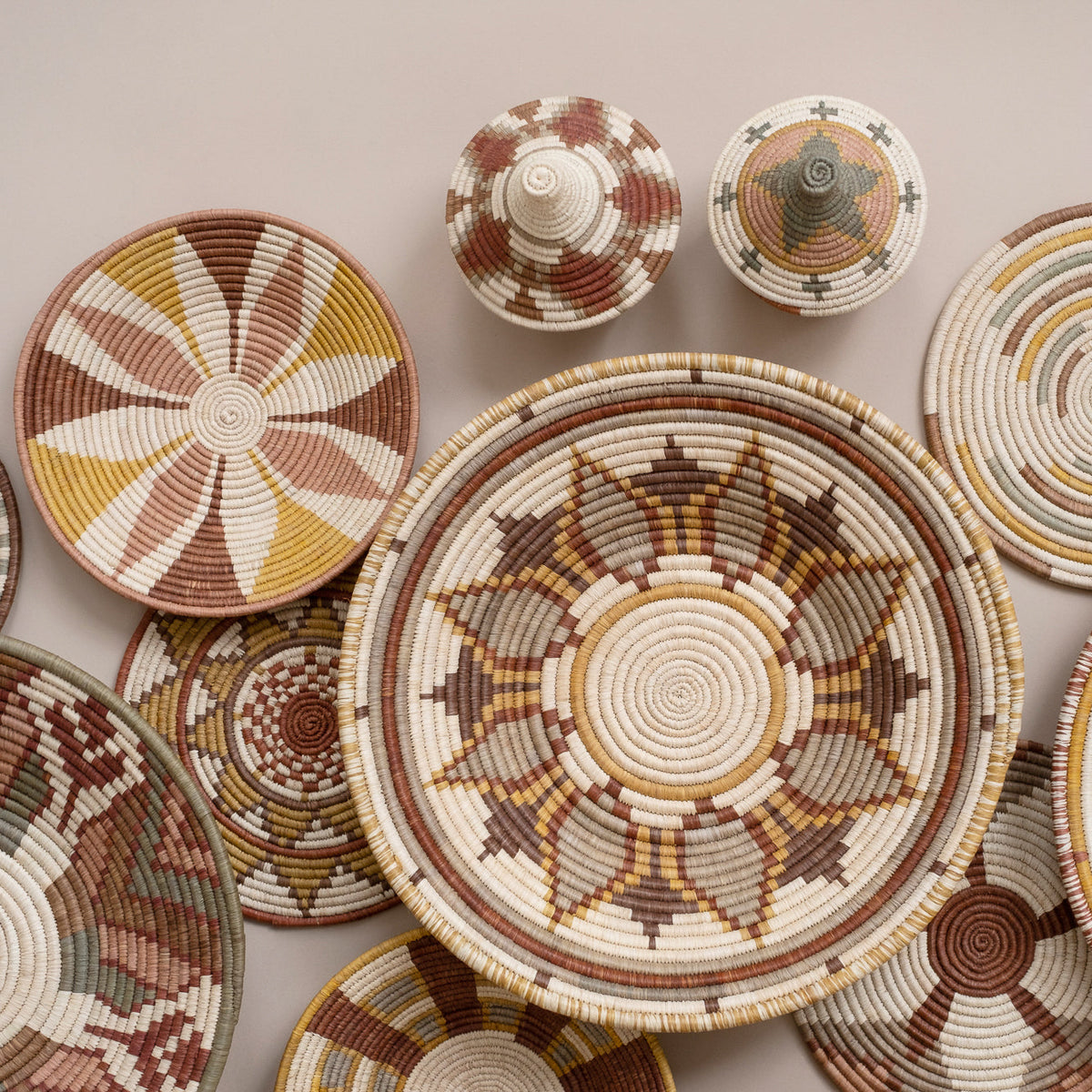 Round woven sunburst coasters with radial patterns in cream, brown, and yellow tones