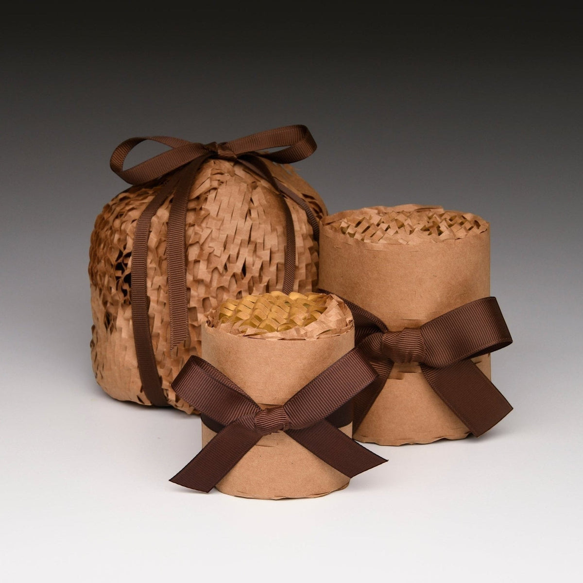 Woven gift basket with kraft paper inserts and brown ribbon bow, no candle shown.