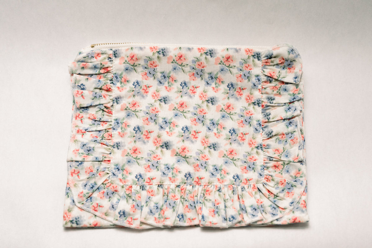 Floral ruffle zipper pouch with gathered ruffle front and zipper top, light blue floral fabric