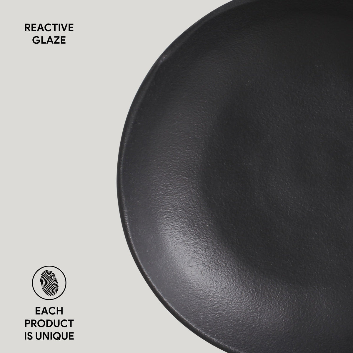 Black reactive-glaze pasta plate close-up with textured finish
