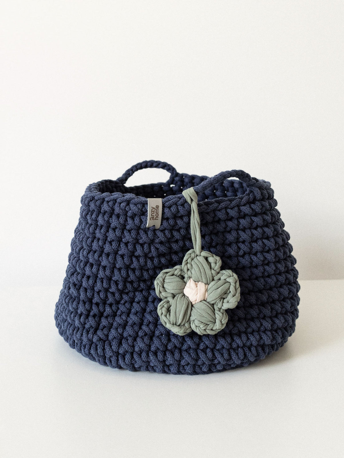 Navy crocheted nursery storage basket with handle and flower applique