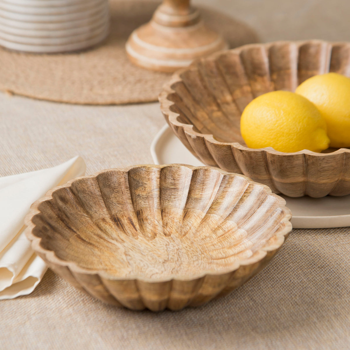 Scalloped natural wood serving bowl with ridged shell edge, side view