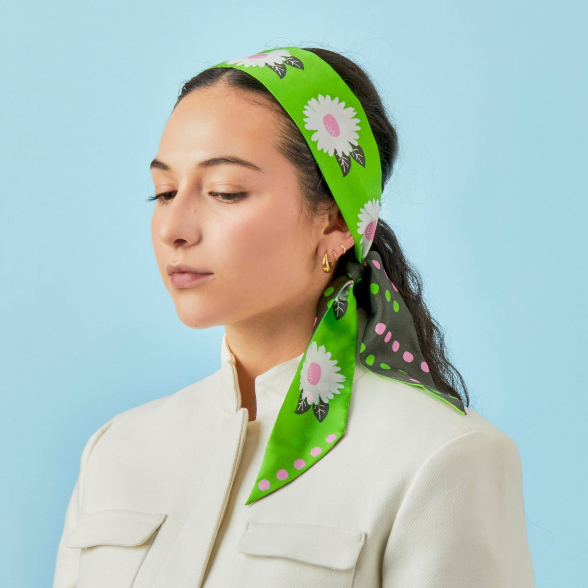 Green and black twilly scarf with daisy flowers, worn as a hair tie