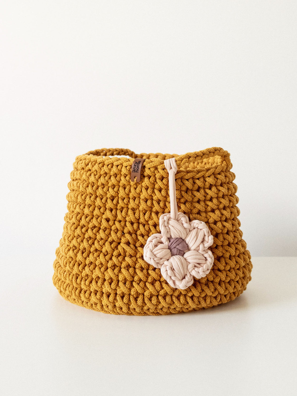 Mustard crocheted nursery storage basket with flower pendant