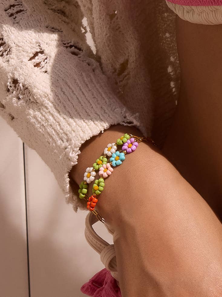 Colorful beaded daisy chain bracelet worn around the wrist.