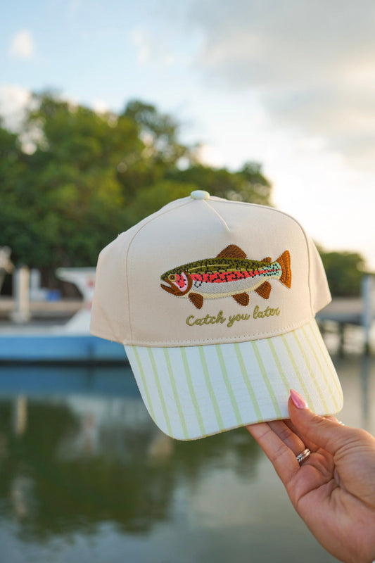 White baseball cap with colorful fish logo and mint green striped brim