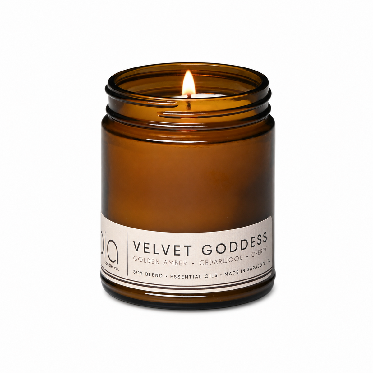 Amber glass candle jar with flame visible through the top opening