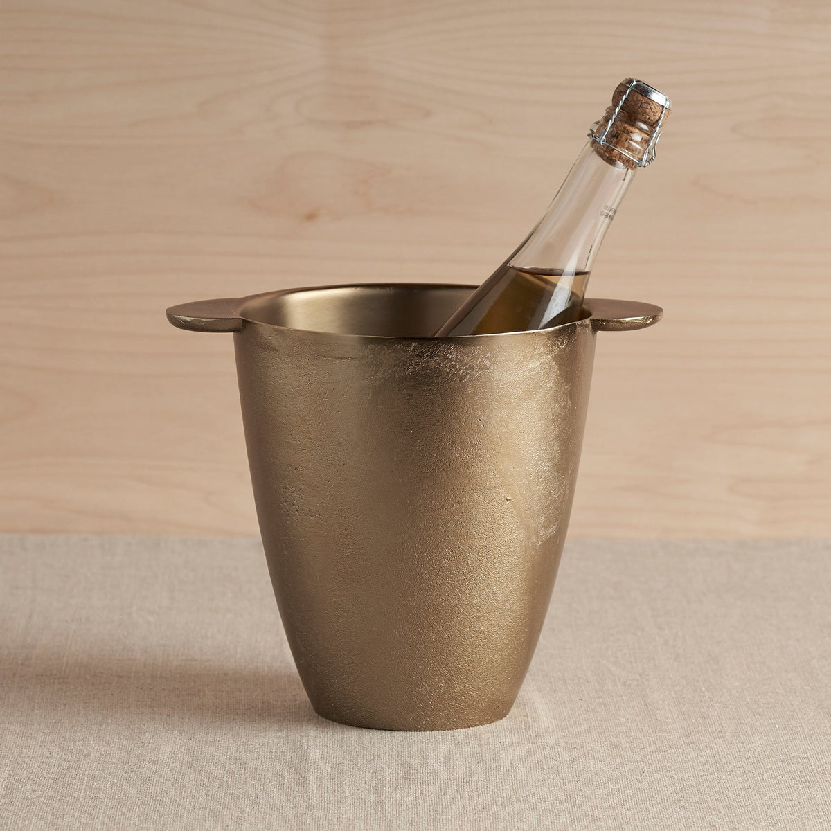 Antique brass wine chiller with flared rim and bottle inside