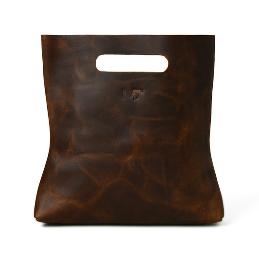 Brown leather handbag front view with top handle cutout and embossed logo