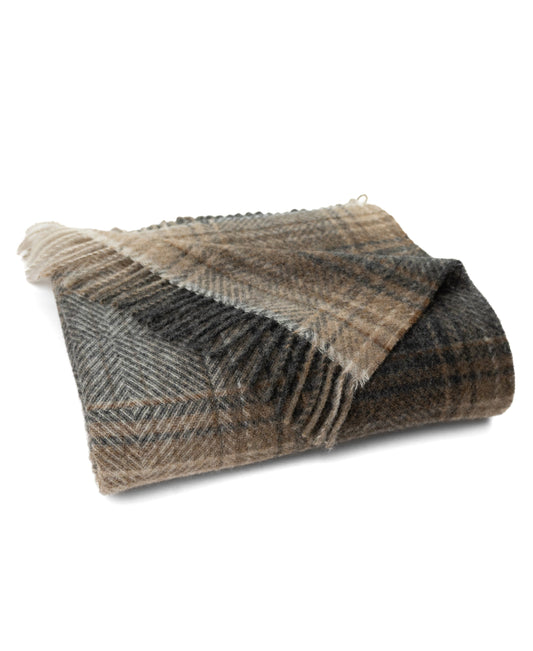 Natural ombre plaid wool throw with fringed ends, draped in a folded stack.