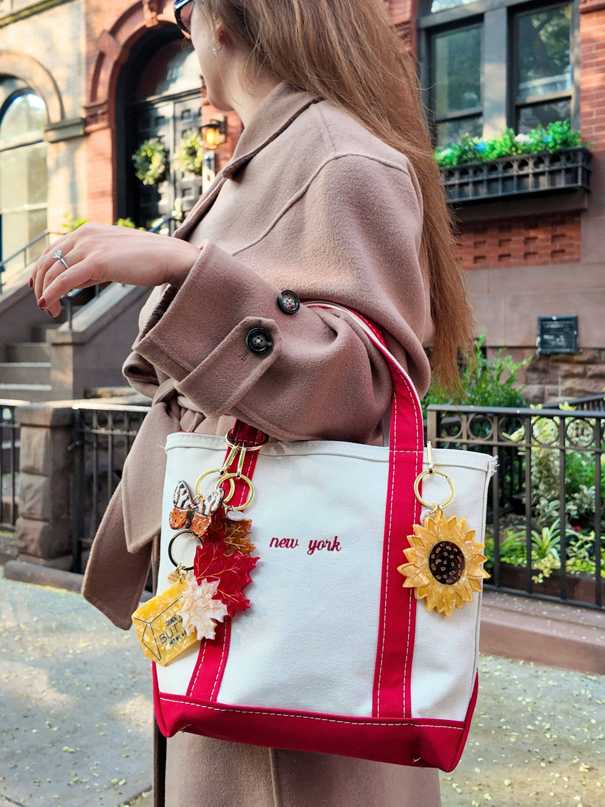 Butter bag charm keychain on red-and-white tote with leaf dangles and gold rings