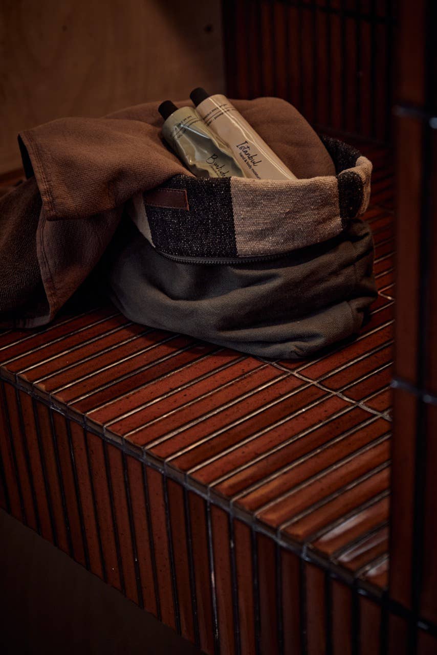 Folded dark brown Turkish hand towel with small label detail